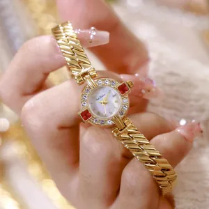 Primer plano del reloj de cadena de oro vintage Bee Sister con diamantes y piedras rojas