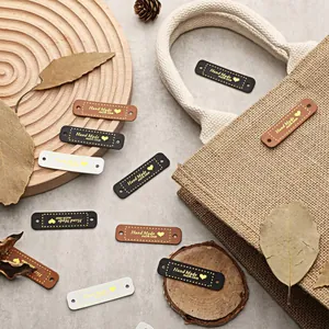 Detailaufnahme verschiedener Lederetiketten "Hand Made with love" für DIY-Kleidungszubehör.