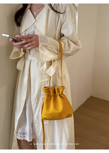 Yellow candy-colored drawstring bucket bag showcased in a minimalist lifestyle setting