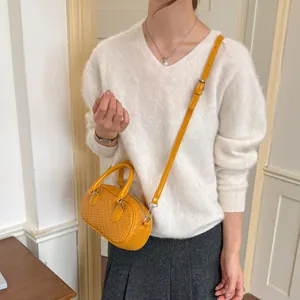 Stilvolle gelbe Handtasche mit Webmuster am Modell mit verstellbarem Schultergurt