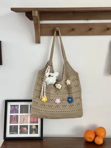 Detailansicht der handgefertigten Häkeltasche mit bunten Strickblumen-Akzenten