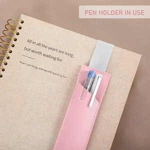Vue détaillée du porte-stylo en cuir PU rose avec bande élastique sur carnet