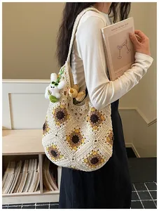 Dettaglio di una borsa tote all'uncinetto fatta a mano con girasoli e ciondolo