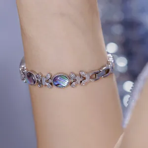 Primer plano detallado de pulsera de mariposa plateada con incrustaciones de nácar de abulón