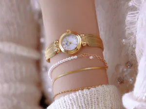 Detalle de cerca del reloj BS Bee Sister dorado con elegantes pulseras en capas