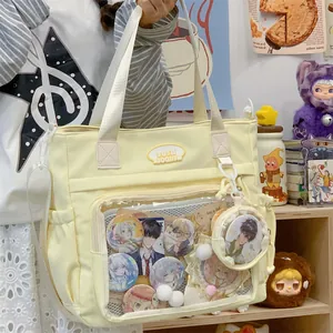 Close-up of a pale yellow canvas tote bag featuring a transparent display window.