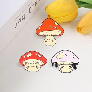 Detailed view of three cute anthropomorphic mushroom enamel pins in red and pink