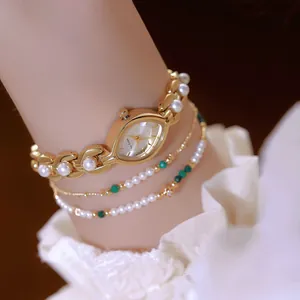 Primo piano di un orologio di lusso vintage dorato con cinturino in perle finte