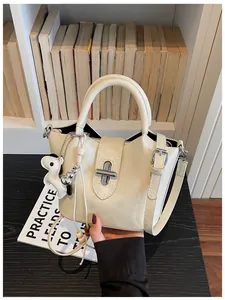 Sac seau chic en cuir grainé crème avec fermoir rotatif argenté et breloque chiot mignonne