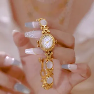 Elegante primer plano de un reloj de pulsera vintage dorado con esfera de nácar blanco puro
