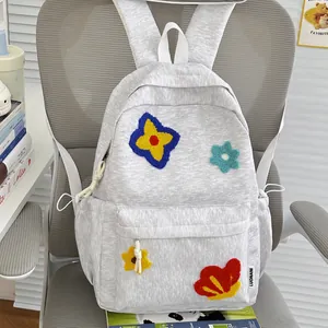 Detailed view of gray school backpack featuring colorful embroidered flower patches