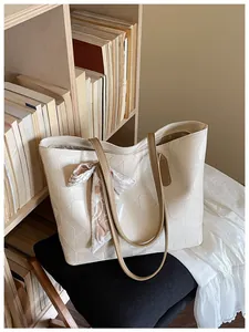 Cream geometric diamond lattice tote bag with tan straps and decorative scarf