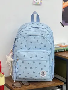 Detailed view of a light blue student backpack with dark star patterns and plush charm