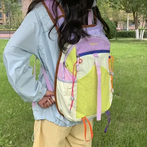 A colorful outdoor hiking backpack with dopamine style colors shown on a model outdoors