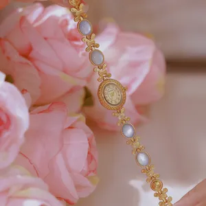 Primer plano del reloj de pulsera Bee Sister en oro con incrustación de nácar y esfera retro.