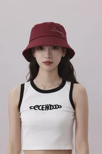 Detalle frontal de un gorro de pescador granate con bordado lucido por una modelo femenina