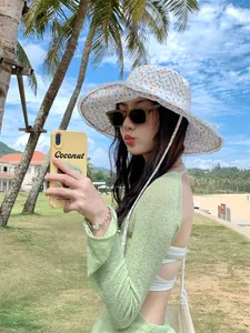 Detailed shot of a floral lace sun hat with a large brim worn by an Asian model outdoors
