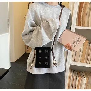 Detailed view of a retro black velvet crossbody phone bag with beaded floral patterns