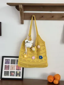 Details einer gelben handgewebten Tragetasche mit bunten Blumenakzenten