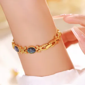 Primer plano detallado de una pulsera dorada con incrustaciones de nácar de abulón natural.