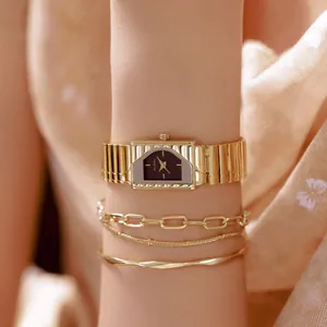 Detalle de un lujoso reloj dorado vintage Bee Sister con pulseras a juego en la muñeca.
