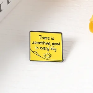 Primer plano de un pin de esmalte amarillo con forma de nota adhesiva e inspiradora