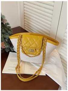 Détail d'un grand sac cabas en cuir matelassé jaune et paille tressée avec bandoulière