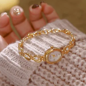 Primo piano di un orologio di lusso vintage dorato con perle finte e numeri romani