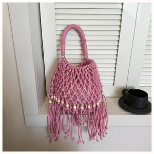 Exquisite close-up view of handmade pink macrame woven handbag with elegant tassels and beads