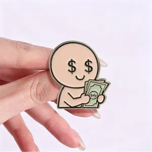 Detail view of a funny metal pin with a character holding money and dollar signs for eyes.