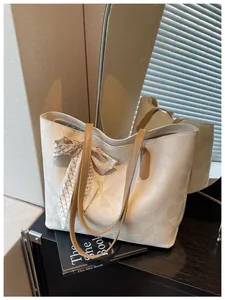 Detail view of large white tote bag with geometric embossing and scarf decoration