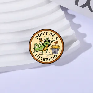 Détail en gros plan d'un pin's émaillé sauterelle avec le slogan Don't Be a Litterbug