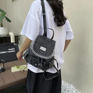 Zaino retrò in denim grigio da donna con finiture in pizzo bianco e tasche esterne.