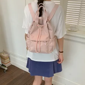 Vista trasera de una elegante mochila rosa con cordón llevada por una joven modelo
