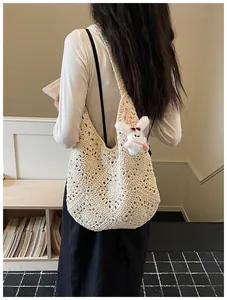Dettaglio di una grande borsa tote all'uncinetto crema con i motivi intrecciati.