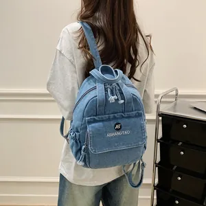 Rückansicht eines lässigen hellblauen Jeansrucksacks für Damen zu einem weißen T-Shirt