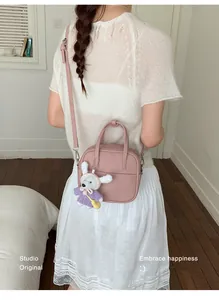 Detailansicht einer stylischen rosa Handtasche mit einem süßen Hasen-Anhänger