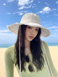 Woman wearing a floral lace bucket hat for summer sun protection on a sunny beach