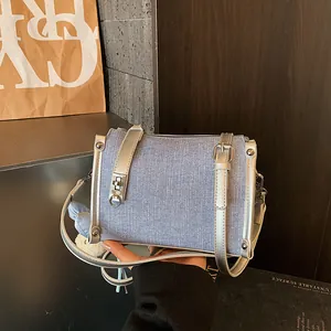 Detailed macro view of a denim crossbody pillow bag with silver straps and buckles
