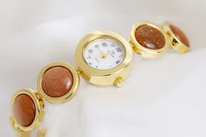 Vista detallada del reloj dorado para mujer con piedra arenisca y esfera blanca elegante