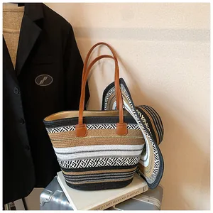 Detail einer gestreiften Strohtasche und eines passenden Hutes auf einem Koffer
