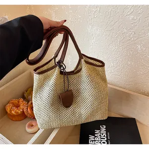 Vista dettagliata di una borsa tote in paglia intrecciata con spalline in pelle marrone estiva
