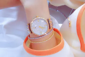 Detalle de reloj de lujo para mujer en tono dorado con cristales brillantes