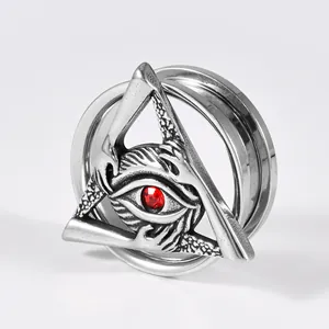 Macro view of stainless steel ear gauge featuring a red-centered evil eye in a triangle