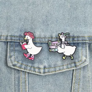 Close-up van twee schattige witte gans emaille spelden op een spijkerjasje zakje