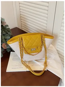 Détail du sac panier en paille tissée avec rabat matelassé jaune et bandoulière