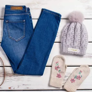 Nahaufnahme von handgefertigten Lederetiketten auf einer Strickmütze und Denim-Jeans