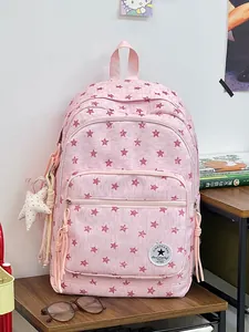 Stylish pink student backpack with red star patterns and matching plush star charm detail