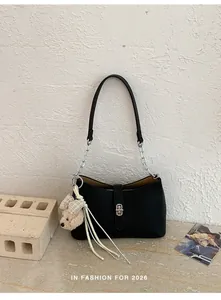 Borsa sottobraccio chic in pelle nera strutturata con chiusura in metallo e ciondolo orso