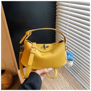 Close-up view of a yellow leather bucket bag featuring a stylish metal toggle closure.
